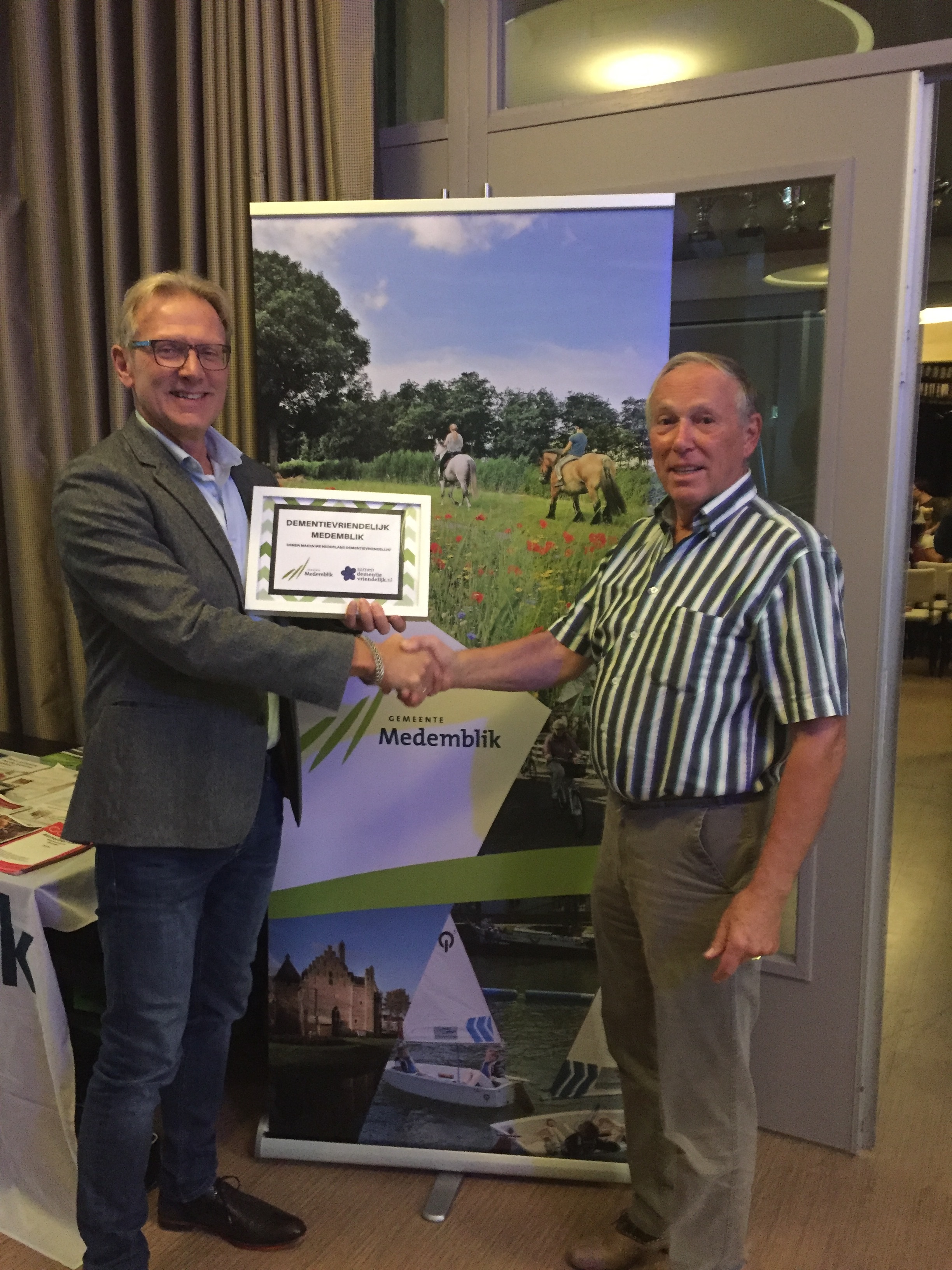 Wethouder Dirk Kuipers kreeg het predicaat Dementievriendelijke gemeente uitgereikt door Wilco Toepoel Alzheimer NL. (Foto: gemeente Medemblik)
