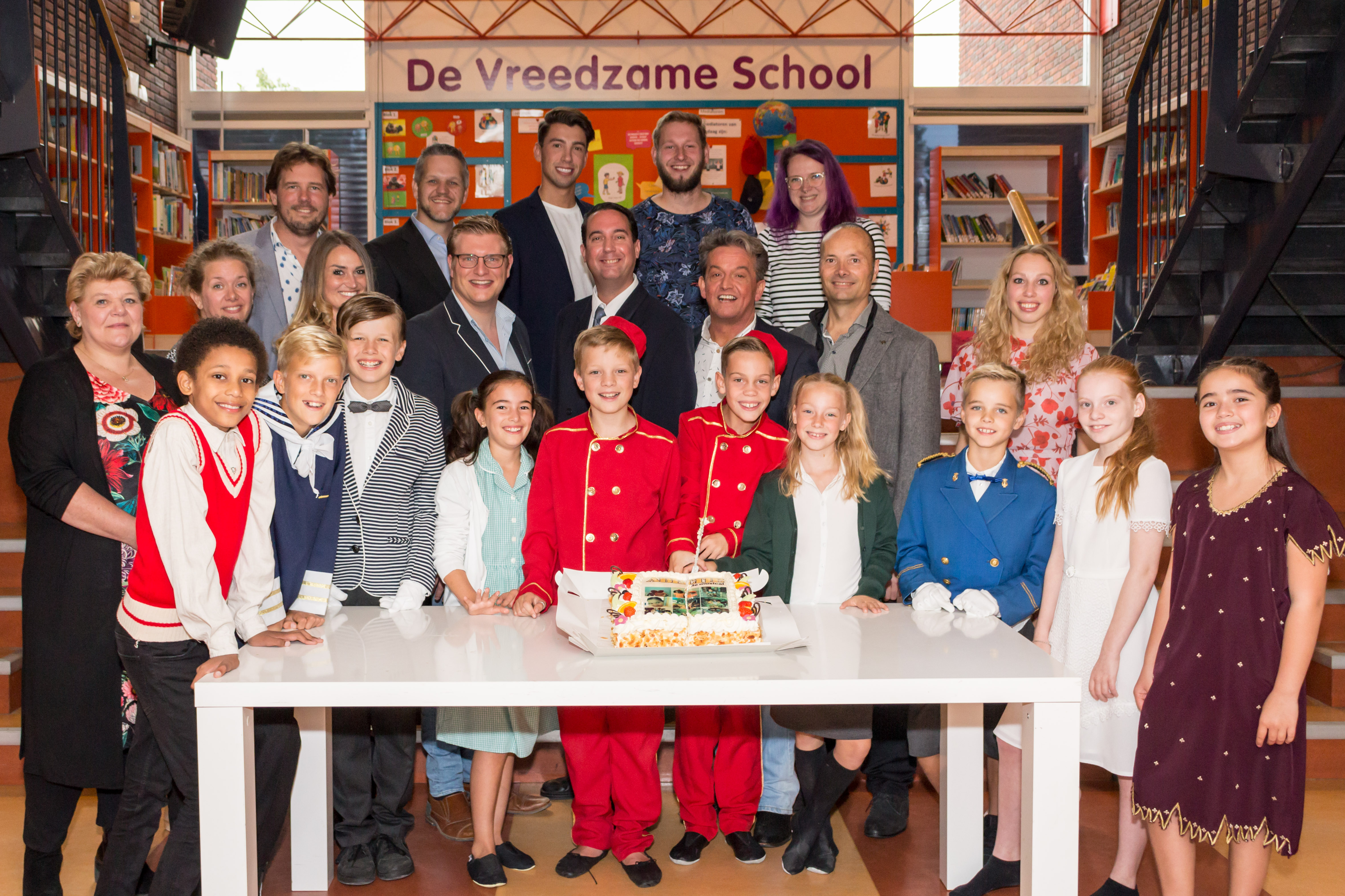 De volwassen- en een deel van de kindercast van Kids with Attitude snijden de taart aan van 'Abeltje de Musical'. (foto AvdK Fotografie)