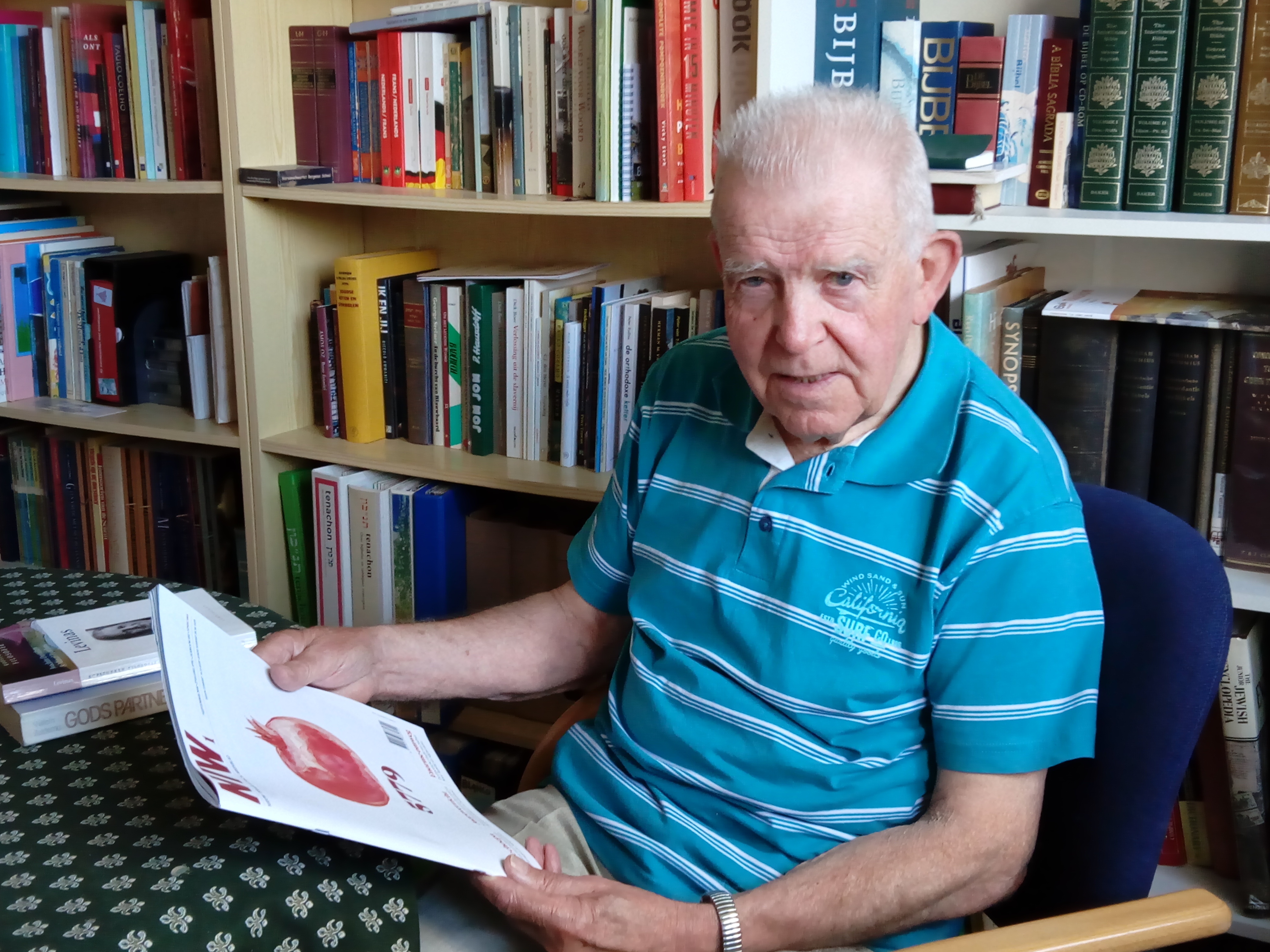 Jan Henneman bladert in het Nieuw Israëlitisch Weekblad, een tijdschrift waarop hij is geabonneerd en waaruit hij veel inspiratie haalt. (Foto: Bos Media Services)