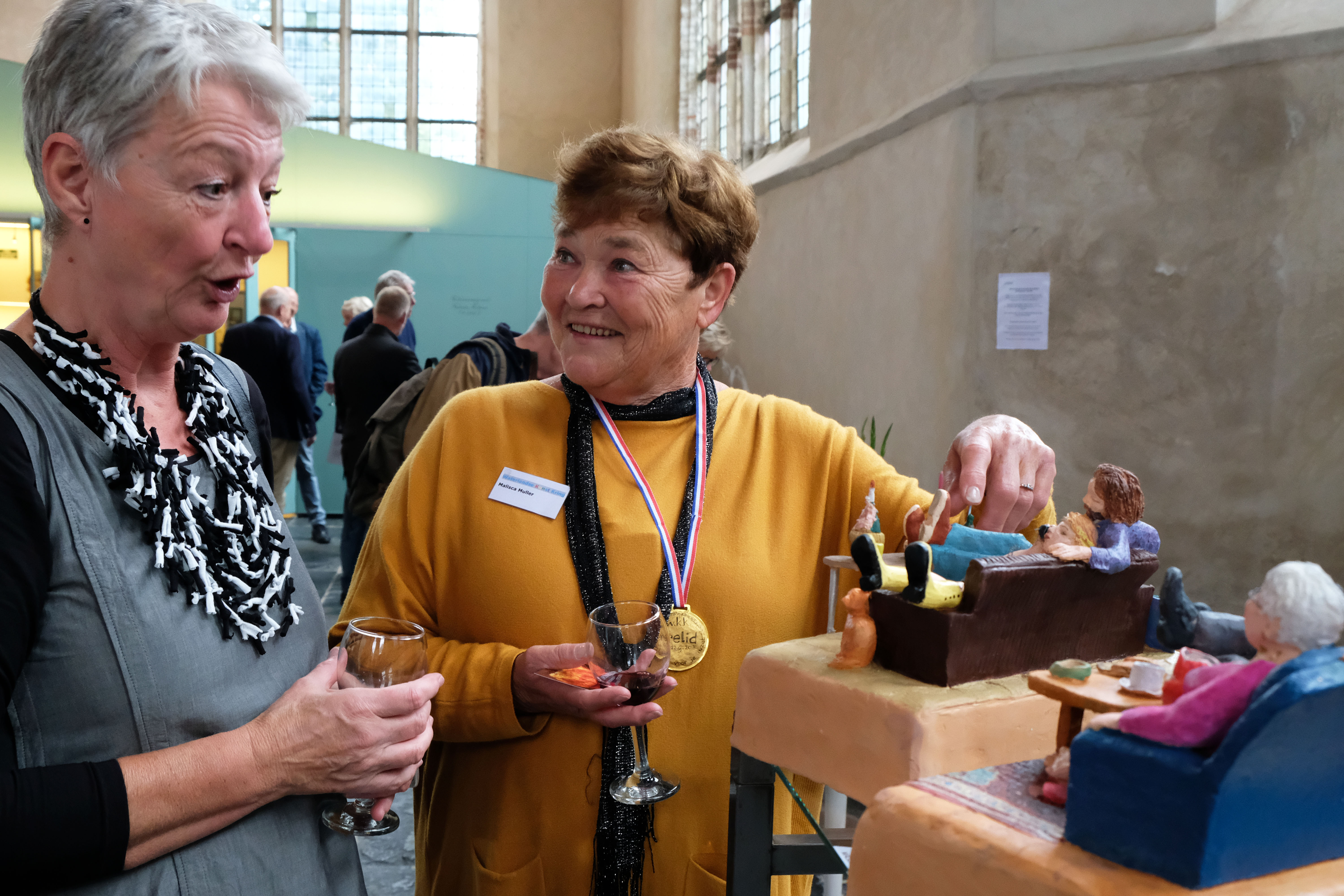 Voorzitter van de Waterlandse Kunstkring Vera Schoone (links) met erelid Malisca Muller (rechts) bij werk van Malisca. (Foto: Ria Houweling/Bouwman)