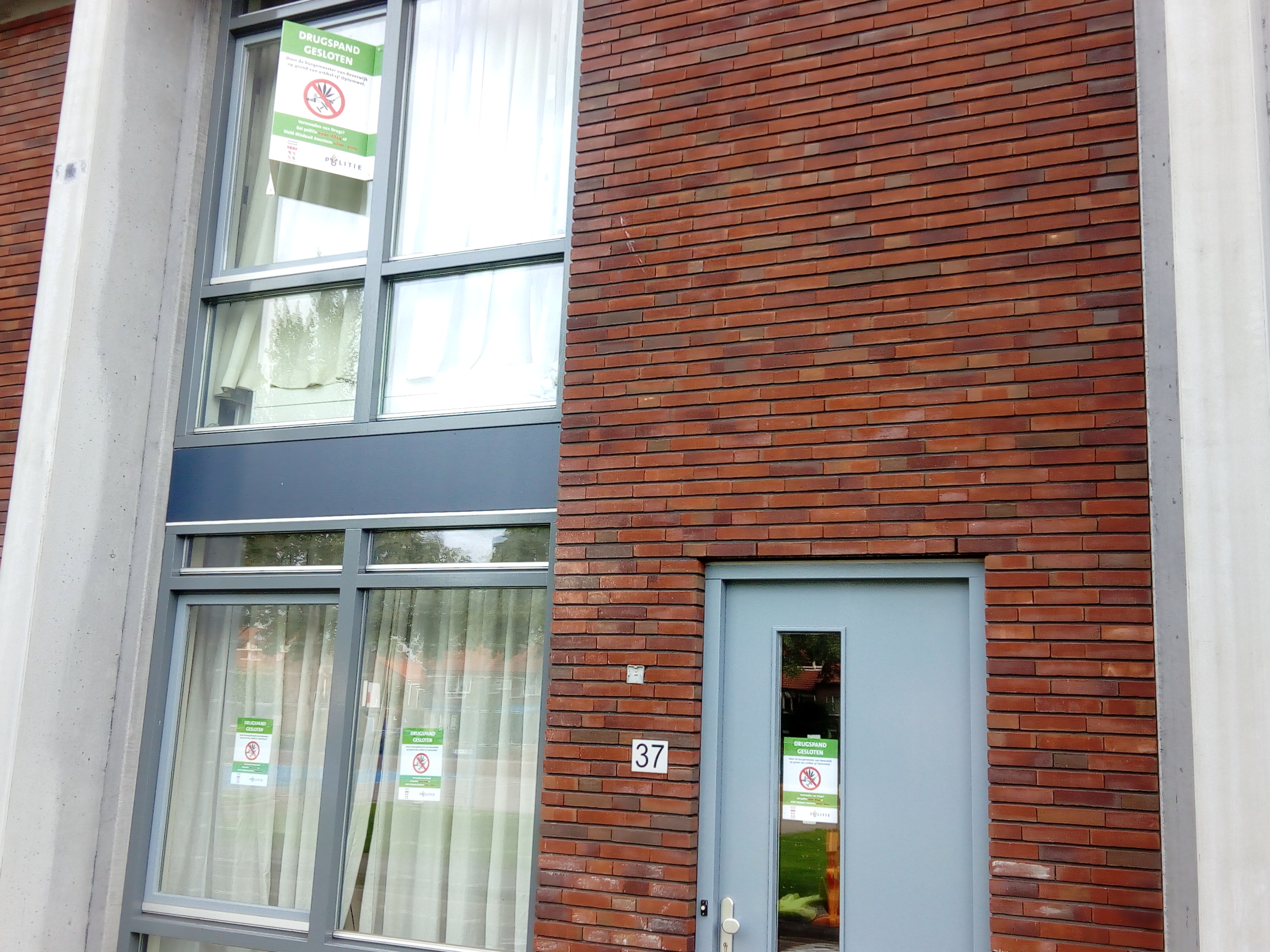 Met de tekst 'drugspand gesloten' worden voorbijgangers geattendeerd op het feit dat de woning door de burgemeester is gesloten. (FOTO: BOS MEDIA SERVICES)