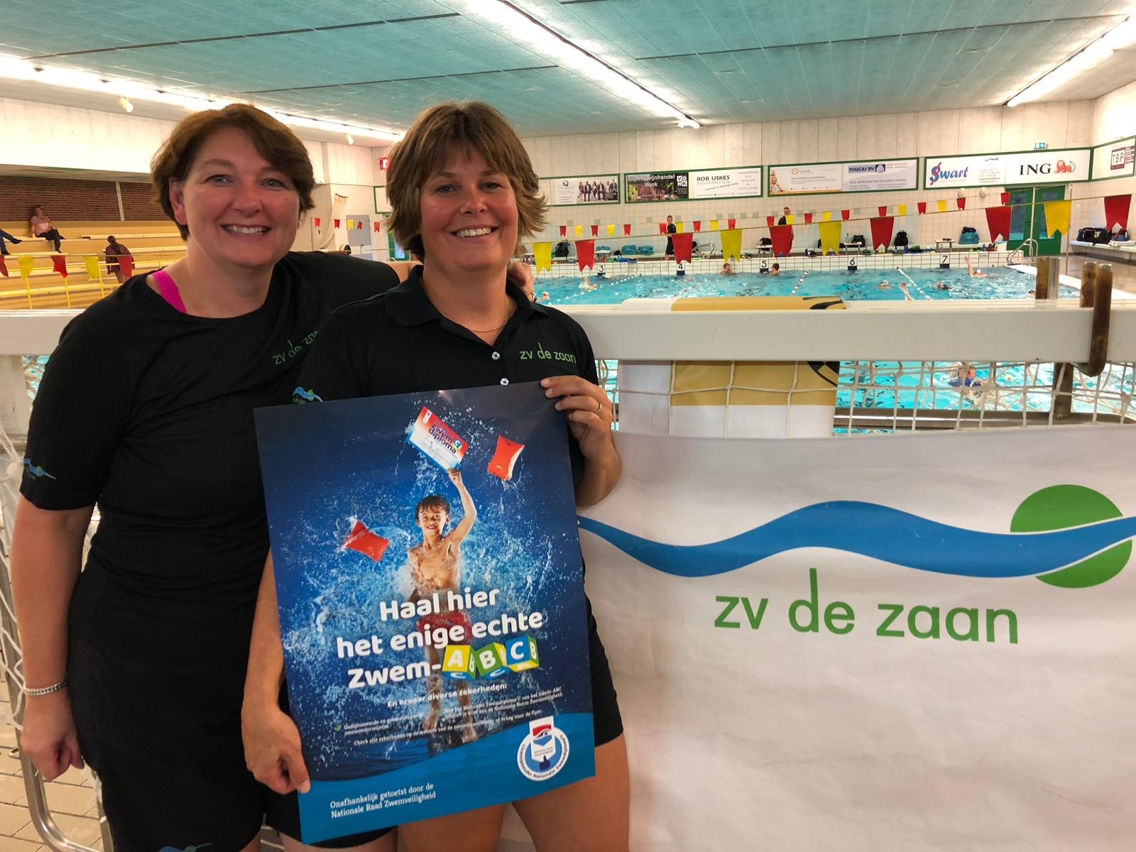Judith Abcouwer (links) en Deborah de Lange (rechts) nemen de Licentie Nationale Zwemdiploma's in ontvangst. (Foto: ZV De Zaan)
