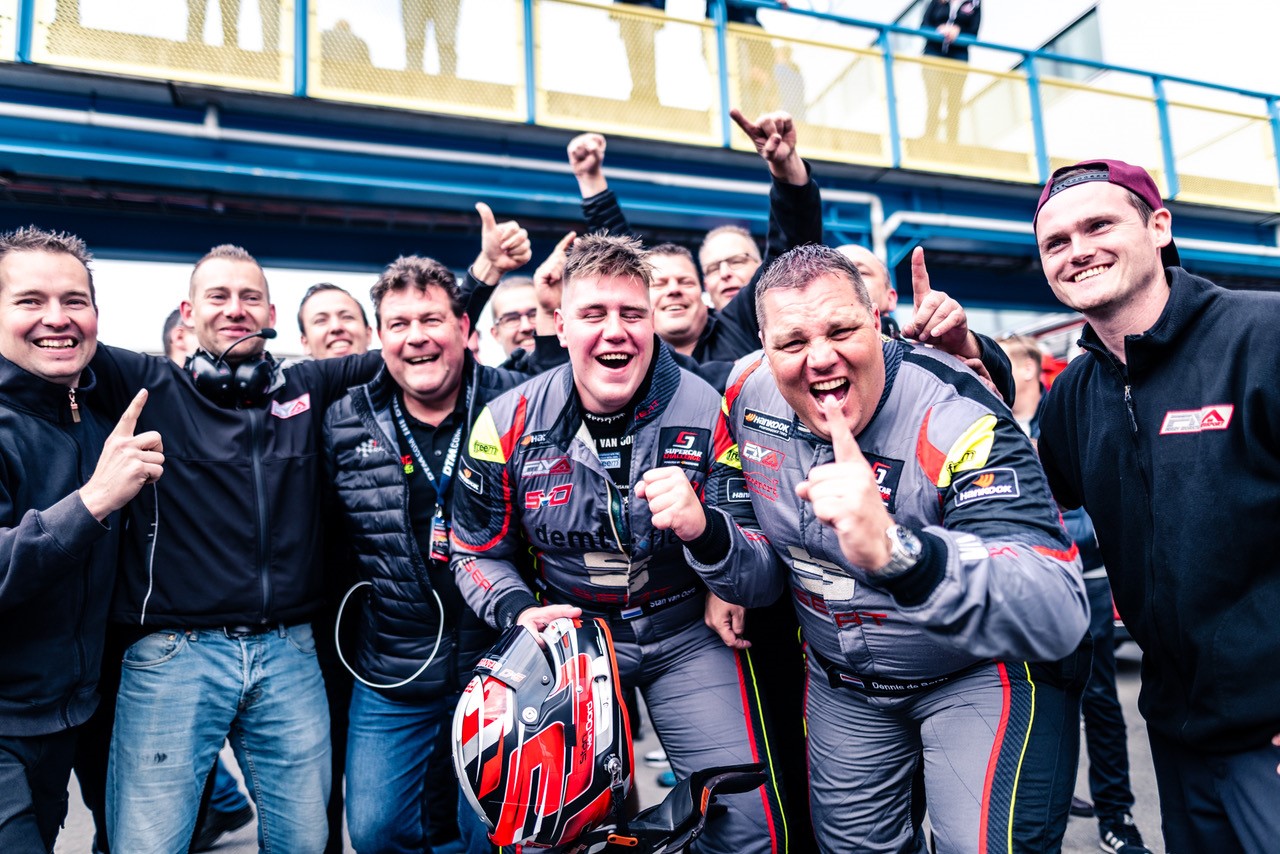 Stan, met helm, en Dennis, ernaast, uitzinnig van geluk met hun derde achtereenvolgende titel. (Foto: Rob Blank)