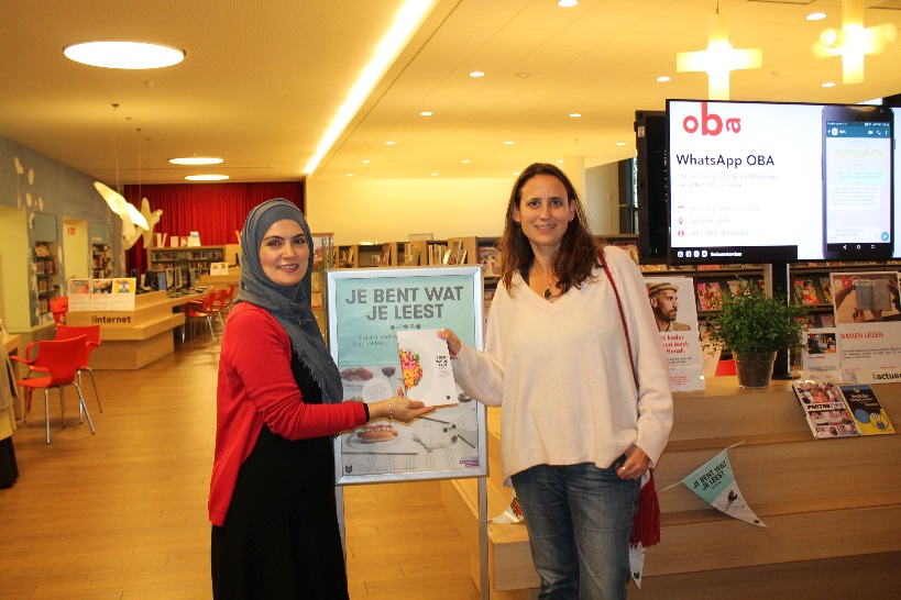 Meliha Koyluoglu overhandigt het boek aan Fiona Remp. (Foto: Hillery - OBA Banne)