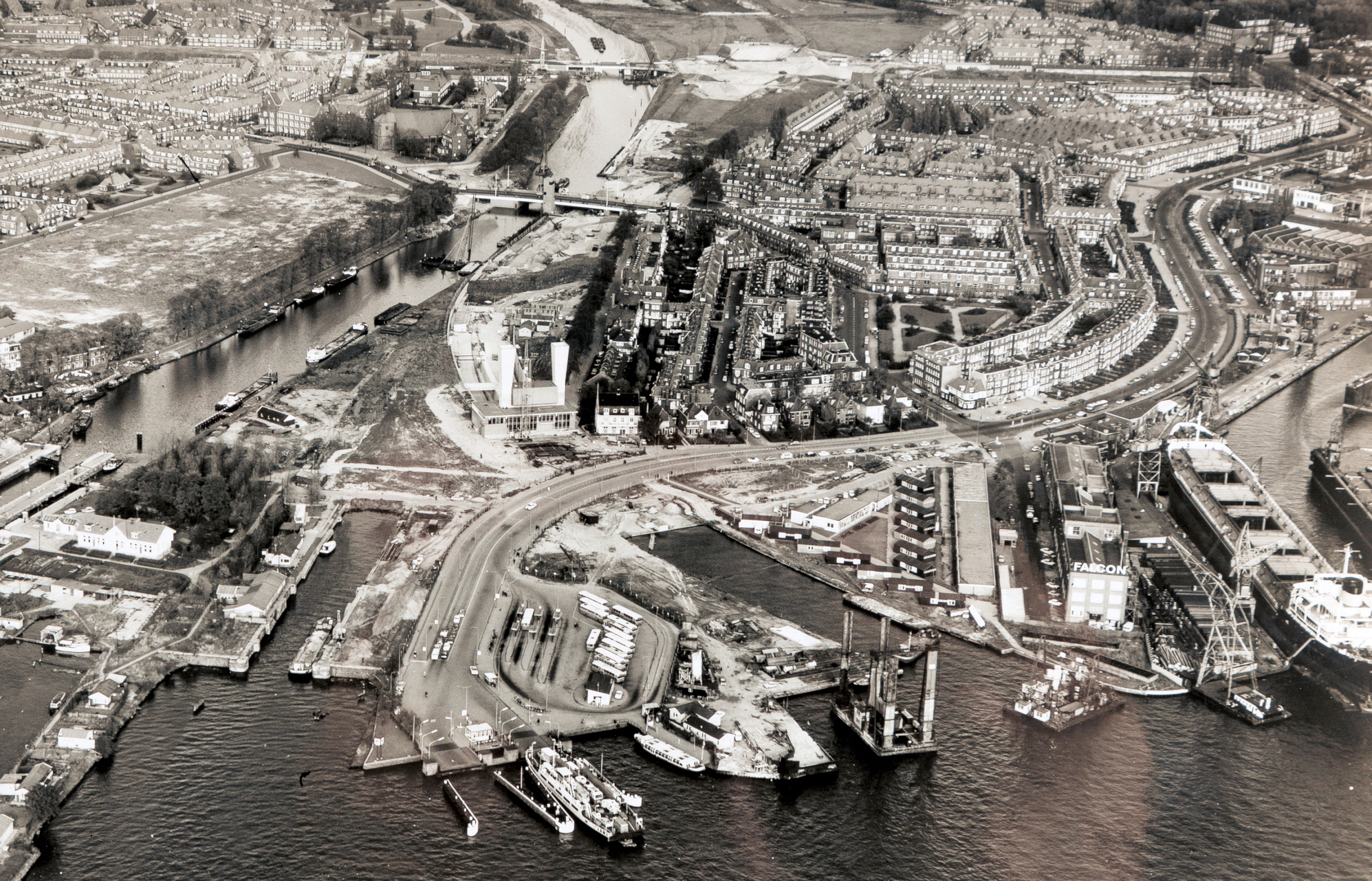 Luchtfoto van aanleg Noordelijke ingang IJ-tunnel 1966. Op de voorgrond: waar nu het IJplein is van links naar rechts Busstation NZH, zinklsleuf tunnel, Valkenweg en de ADM. Daarachter de Meeuwenlaan en de Vogelbuurt. (Foto:, Stadsarchief Amsterdam)