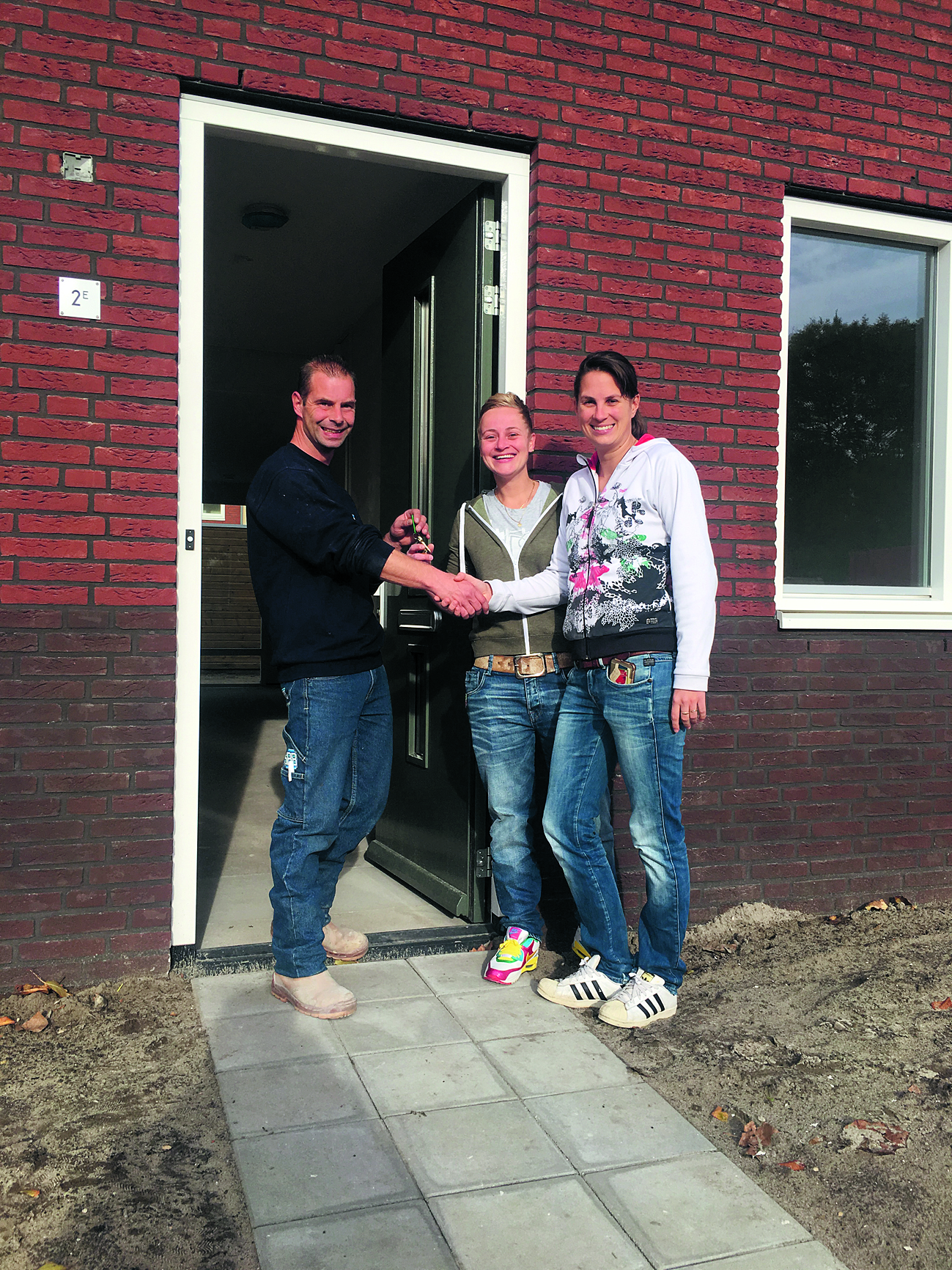 Uit handen van uitvoerder Johan Schelvis ontvingen Iris Zonneveld en Caroline Sinnige vorige week de sleutel van hun nieuwe woning. (FOTO: SMIT'S BOUWBEDRIJF)