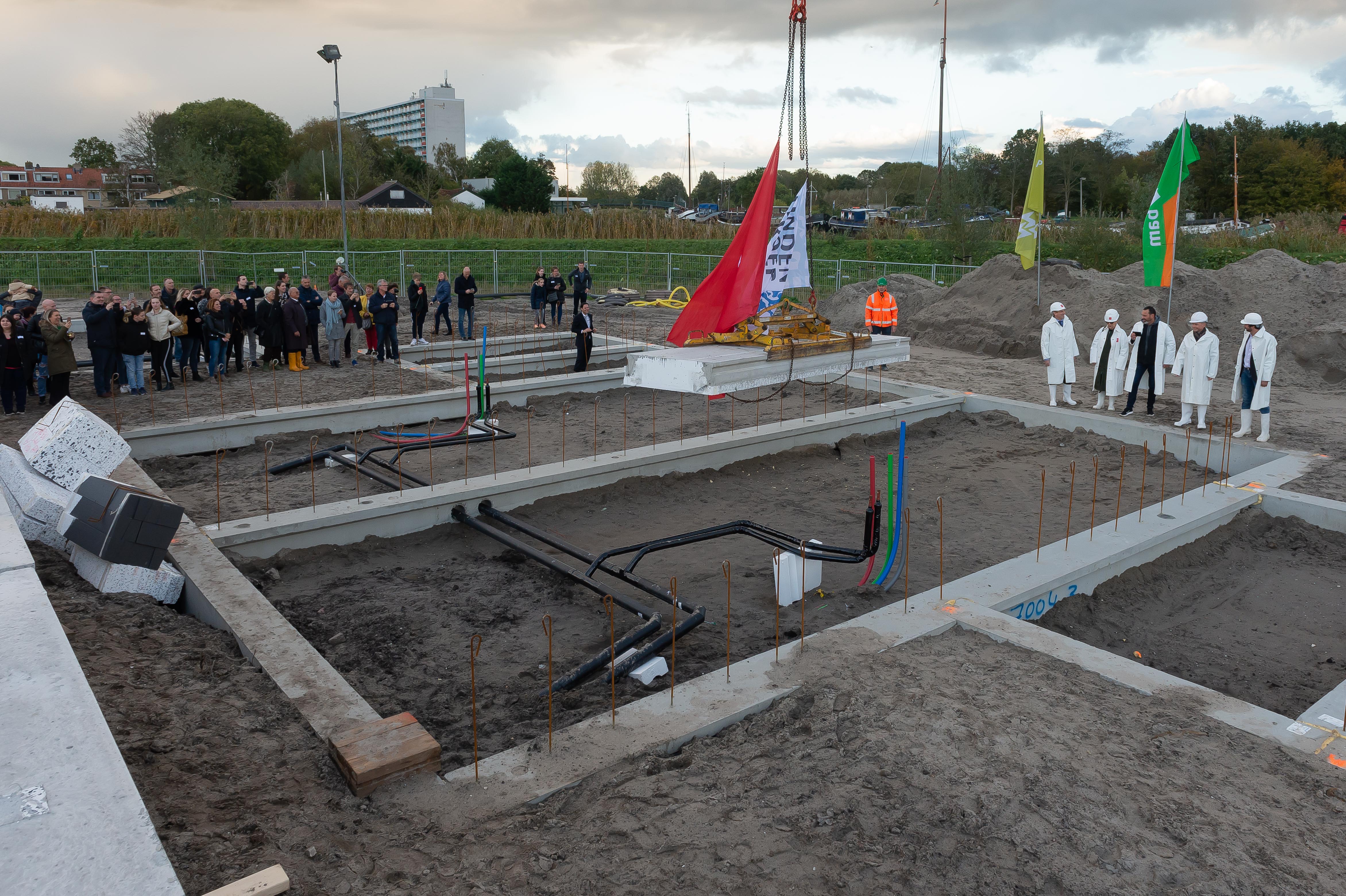 Wethouder Thijs Kroese, Peter Heuvelink, directeur AM Noordwest en Jan van der Linden, directeur van Linden Groep, geven samen symbolisch het startsein voor de bouw door het leggen van de vloer op de begane grond van een van de woningen. (Foto: Han Giskes)