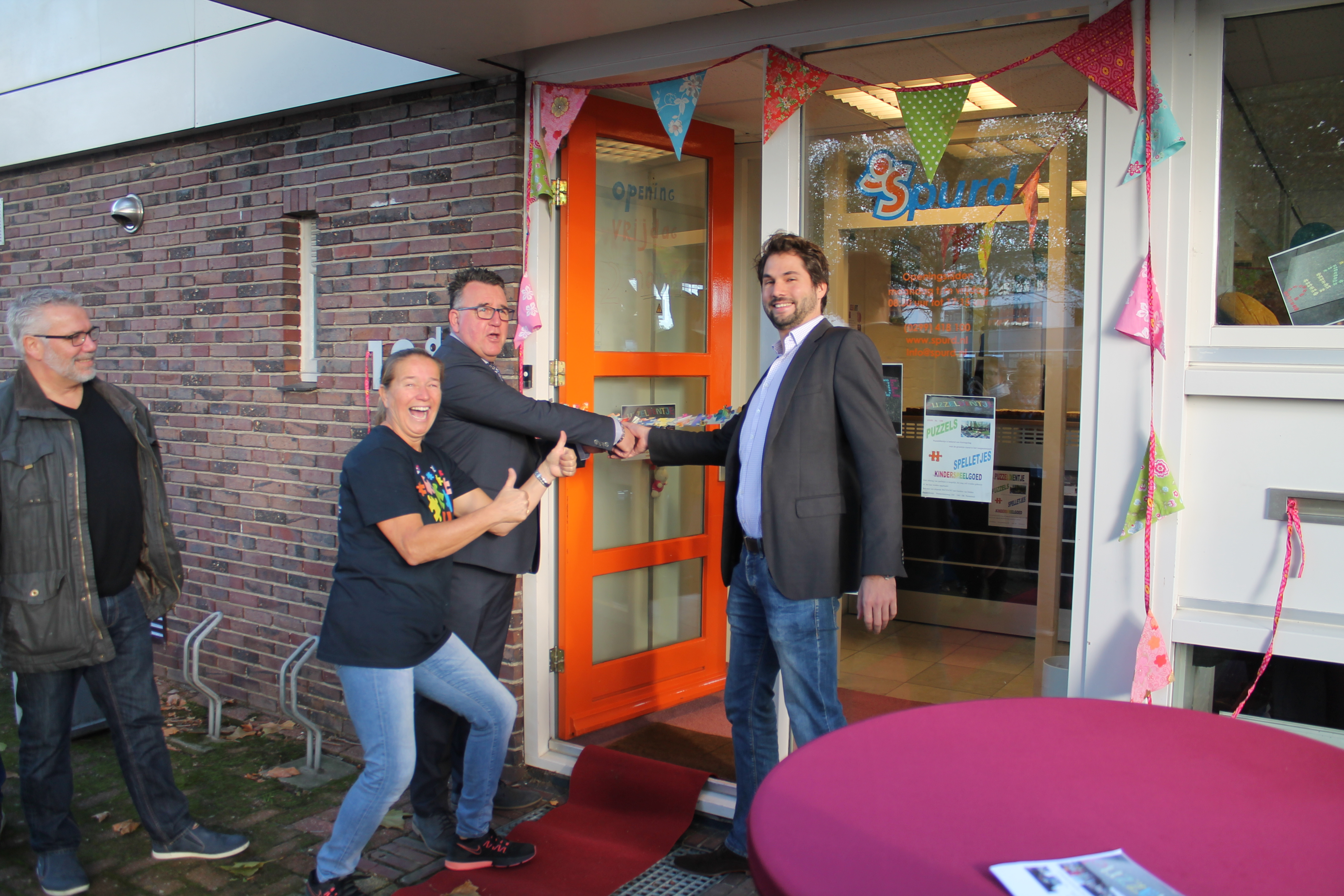 Gerdien van Delden (tweede van links) kijkt tevreden toe hoe Thijs Kroese en Mario Hegger de winkel openen. (Foto: RM/Michael Brouwers)