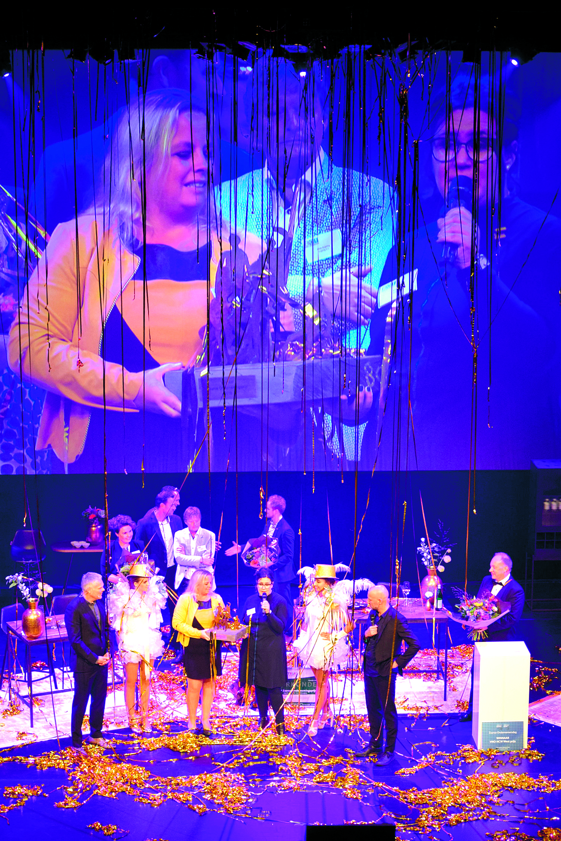 Winnaars Directeur Mandy Beets (met microfoon) en manager tussen de feestslingers. (Foto: YvdD/RM)