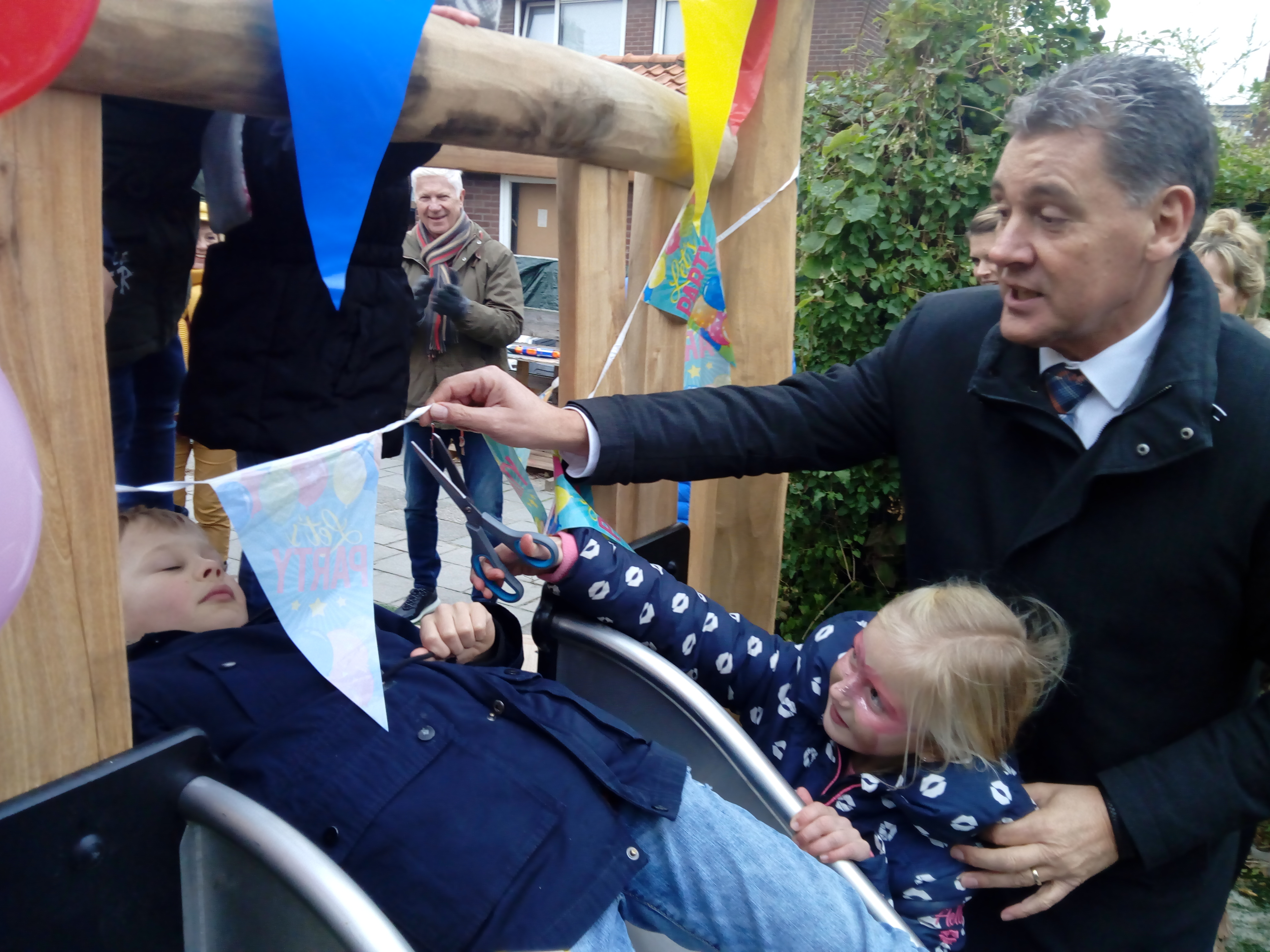 Benjamin (8) kon haast niet wachten om als eerste van de glijbaan af te glijden, nadat Ninthe (6) samen met wethouder Aad Schoorl de vlaggenlijn doorknipte. (FOTO: BOS MEDIA SERVICES)