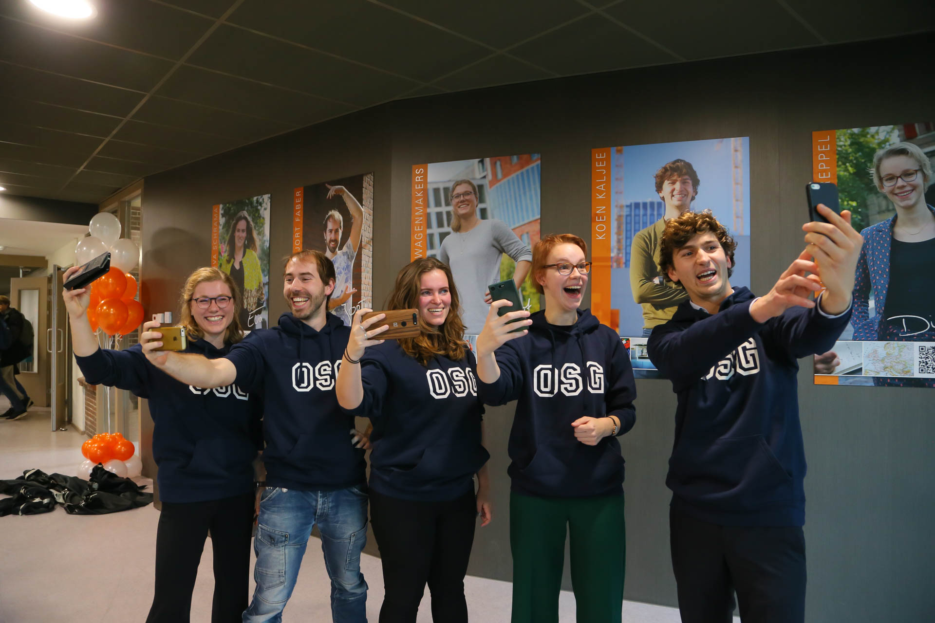 De vijf oud-leerlingen poseren voor een super-selfie bij hun fotogalerij: Margot Wagenmakers, Jort Faber, Eva Schrama, Dieuwertje Toereppel en Koen Kaljee. (Foto: aangeleverd)