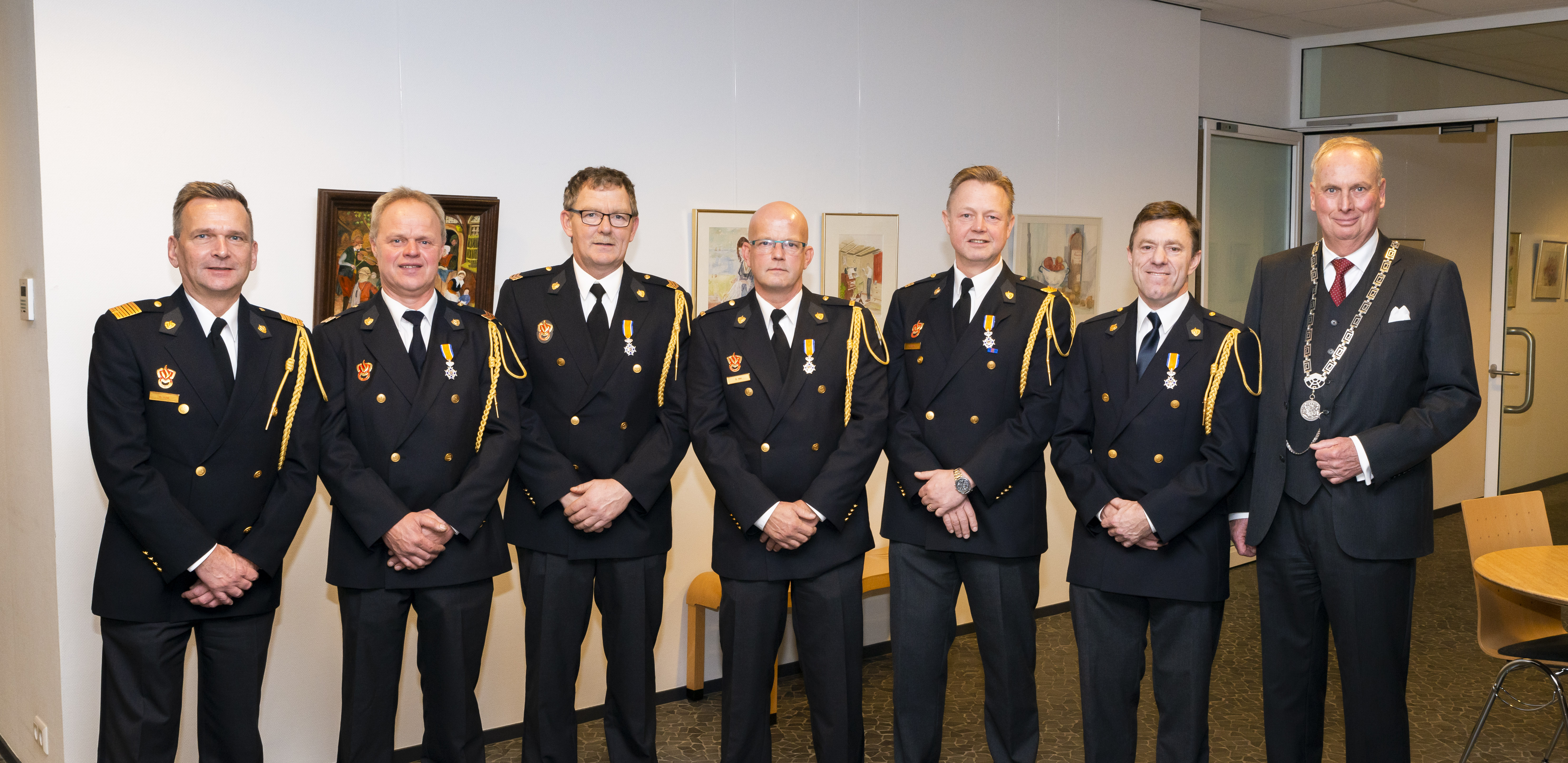 De brandweervrijwilligers tonen hun lintje. (Foto: gemeente Koggenland)