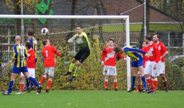 Keeper Rick Weeda van FIOS werkt de bal weg.