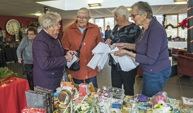 De enveloppen met nummers voor de loterij vonden gretig aftrek, want wie weet, won je wel een leuke kerstdecoratie... (Foto: Jos Uijtdehaage).