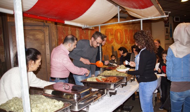 Het eten werd verzorgd door Hussam Karkas (in roze overhemd) met zijn vrouw, die drie jaar geleden vanuit Syrië naar Nederland kwamen. Hij gaat trouwens aan de slag als kok in het restaurant van WSW Ouddorp.