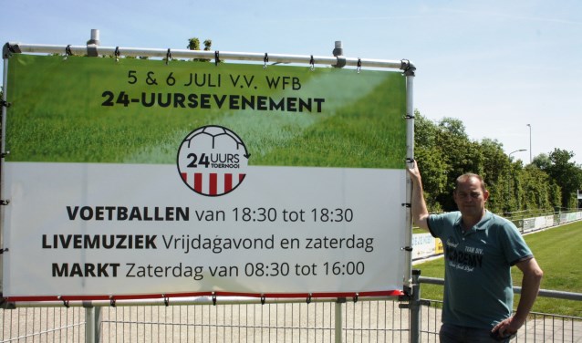 Leon Struijk, één van de organisatoren, bij het reclamebord van het 24-uurs toernooi.