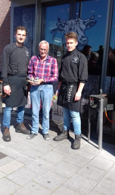 Adrie Bestman met zijn winnende duif, geflankeerd door medewerkers van Slagerij Zuidland.