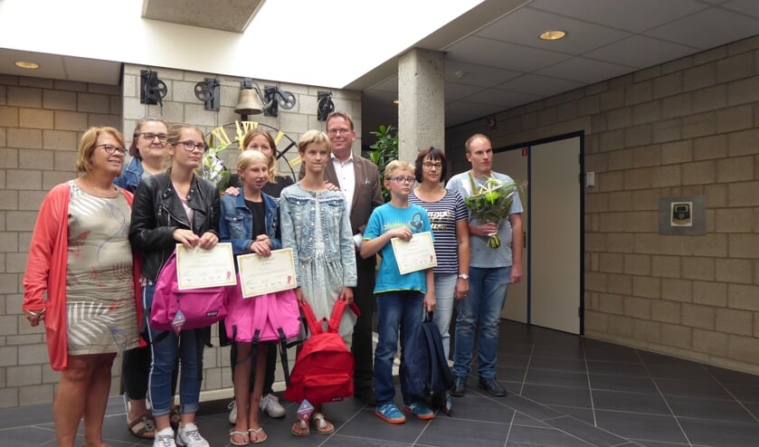 De trotse gecertificeerden van de Reiskoffer samen op de foto met ouders. verzorgers, vrijwilligers, opleiders en de wethouder.
