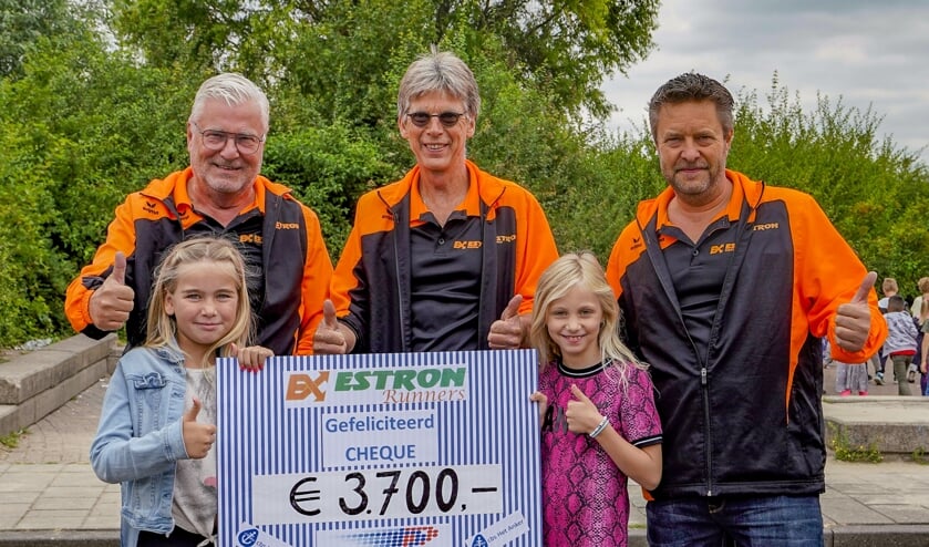 Leerlingen van Het Anker overhandigen de opbrengst van de obstacle run.