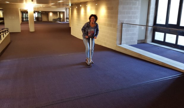 Huurder Fiola van Nunen op haar vervoersmiddel door het gebouw.