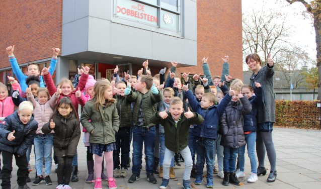 Directrice Hanneke Meulblok (rechts) met leerlingen op het plein van de jarige school
