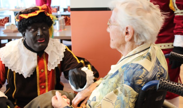 Piet geeft pepernoten aan een 100-jarige inwoner van De Vossemeren in Nieuw-Vossemeer
