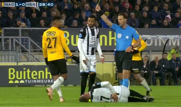 Danny Makkelie trekt de gele kaart voor Kali na de charge op Peterson.