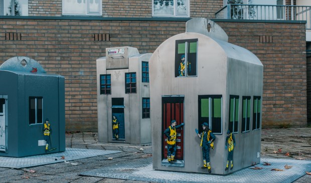 De tot huisjes omgetoverde afvalbakken die op verschillende plaatsen verschijnen.