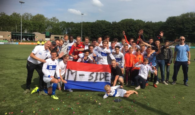 De selectie, technische staf en supporters vieren de promotie. FOTO BESTUUR MOC'17