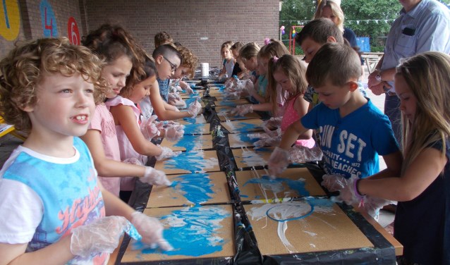 Leerlingen leven zich uit tijdens een schilderworkshop.