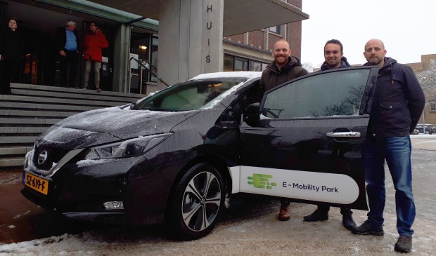 Wethouder Sem Stroosnijder en David Tolhoek en Sjoerd de Jong (vlnr) van de stichting bij de elektrische deelauto.