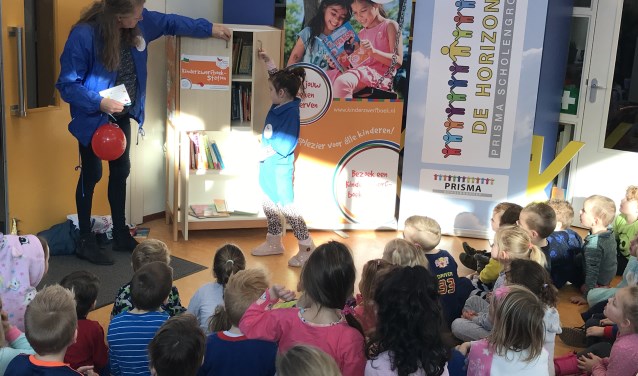 De jarige Ruhmen mag helpen met de opening van het kinderzwerfboekenstation.