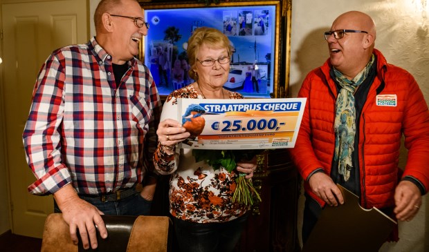Nico en zijn vrouw Annie uit Roosendaal werden verrast door Postcode Loterij-ambassadeur Gaston Starreveld met de PostcodeStraatprijs-cheque.