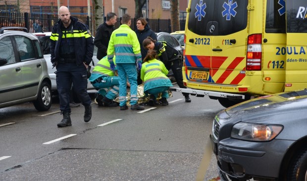De scooterrijder wordt in de ambulance behandeld.