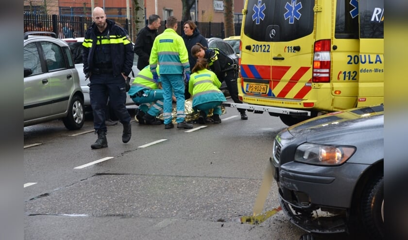 De scooterrijder wordt in de ambulance behandeld.