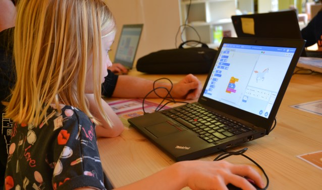 Noa (7) leert samen met haar vader hoe je moet programmeren FOTO REMKO VERMUNT