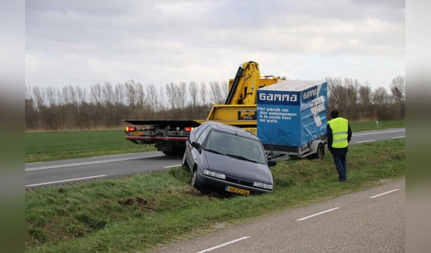 Een bergingsbedrijf haalt de auto uit de sloot.
