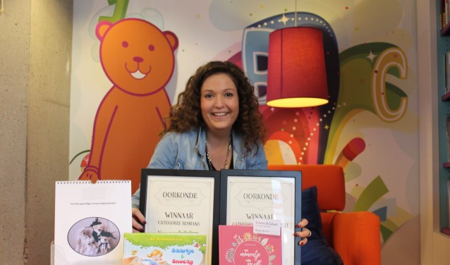 Vivianne de Caluwé met haar boeken en teddyberen kalender in bibliotheek Het Markiezaat Steenbergen.