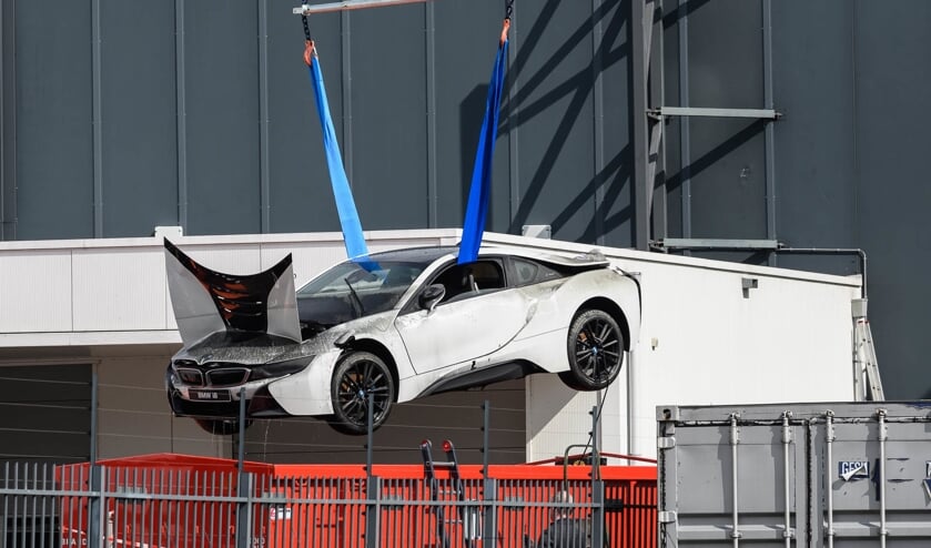 De peperdure elektrische sportauto wordt omhoog getakeld uit de blusbak