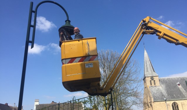 Wethouder Jan Harmsen vervangt de oude lamp voor een nieuwe led-lamp FOTO REMKO VERMUNT
