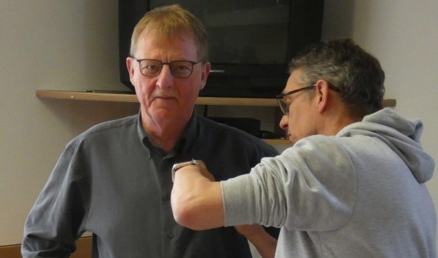 Erelid Dick Schinkel krijgt het speldje uitgereikt door PSR-voorzitter Alex Achterhuis.
