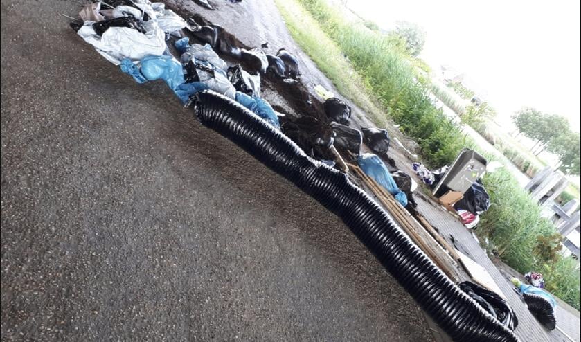 Het afval ligt over de hele weg verspreid.