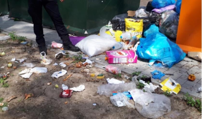 Er lag een enorme hoop afval naast de containers.