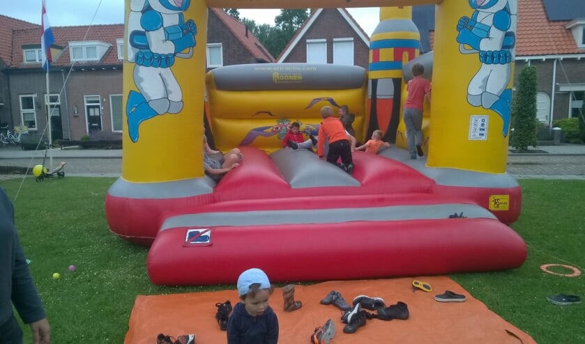 Kinderen vermaken zich prima op het springkussen tijdens de buitenspeeldag.