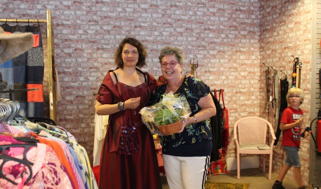 Marina Fidder van gemeente Steenbergen past een galajurk in De Ontmoetingswinkel van Rian Liefhebber.