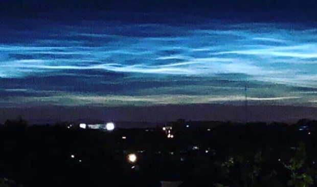 De lichtgevende wolken vanaf vijf hoog in de Sandenburgstraat