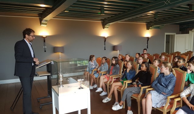 Stadsarchivaris Van den Kieboom vertelt de leerlingen over de beker.