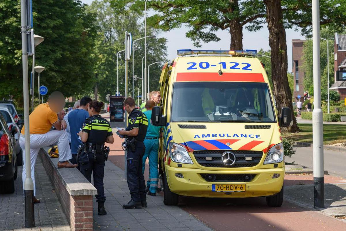 De ambulance zal de gewonde fietsster neer het ziekenhuis vervoeren.