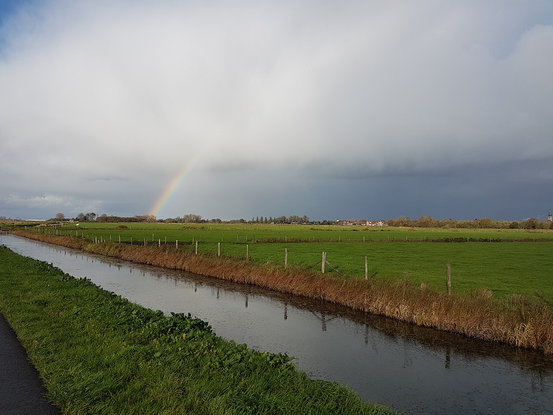 Buienwolk met regenboog boven de Haagse Beemden polder