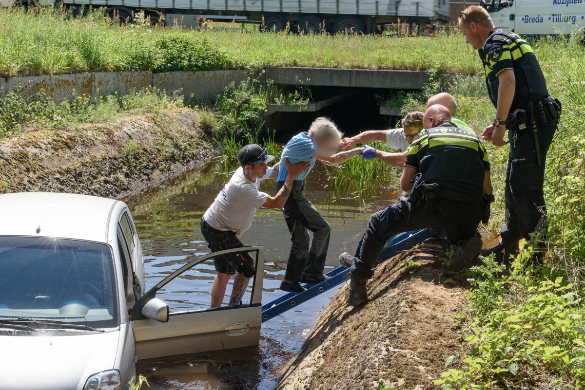 Oud vrouwtje rijdt in sloot, omstander schiet te hulp